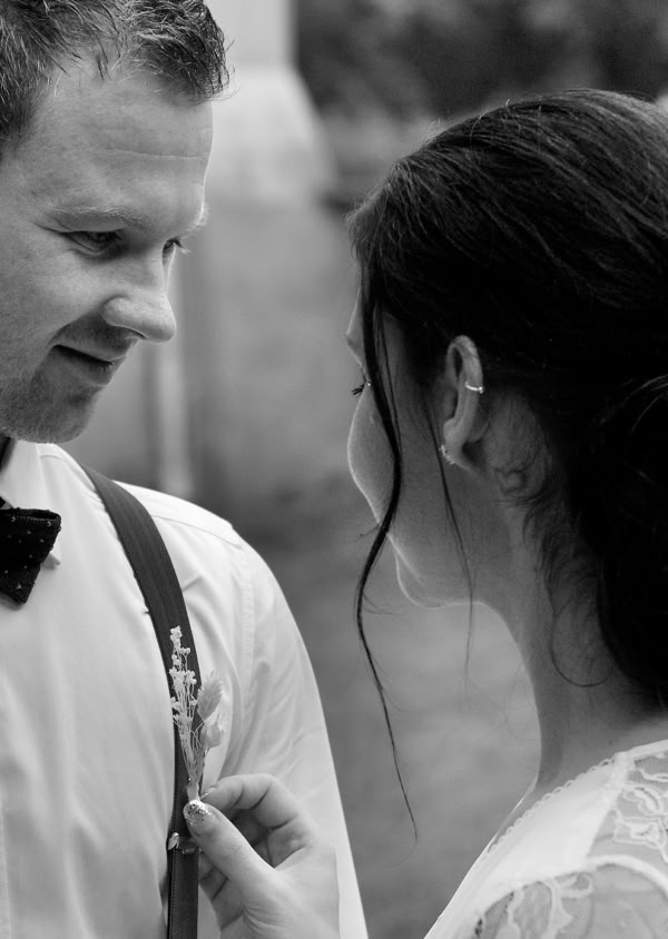 Ein Mann in Hemd und Hosenträgern mit Fliege steht einer Frau gegenüber, die ein Kleid trägt.